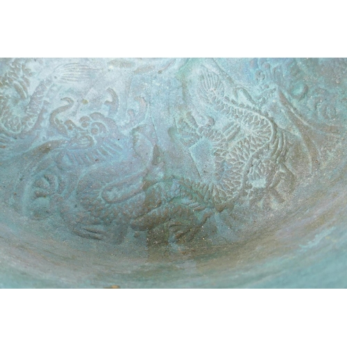 26 - An antique Chinese bronze two handled spouting bowl with dragon decoration, 30cm diameter