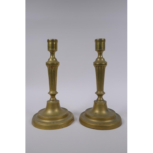 34 - A pair of antique brass column candlesticks, 25cm high