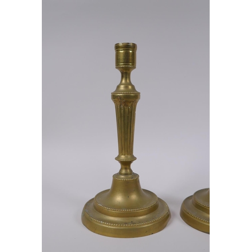 34 - A pair of antique brass column candlesticks, 25cm high