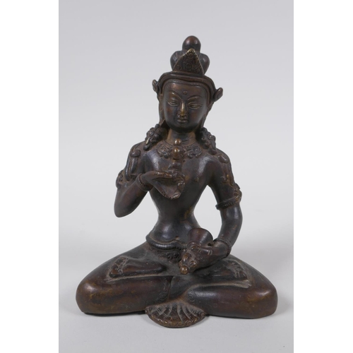 43 - An antique Tibetan bronze figure of Buddha holding a vajra and bell, 16cm high