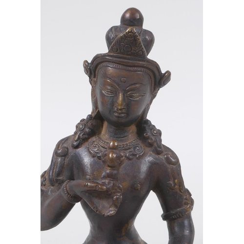 43 - An antique Tibetan bronze figure of Buddha holding a vajra and bell, 16cm high