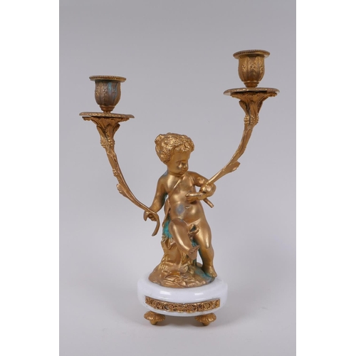 49 - A gilt metal two branch candlestick in the form of a putti, 30cm high