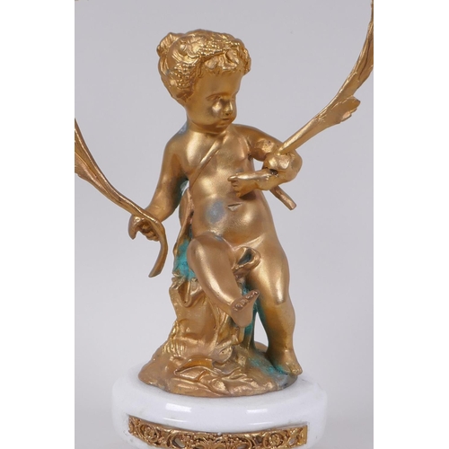 49 - A gilt metal two branch candlestick in the form of a putti, 30cm high