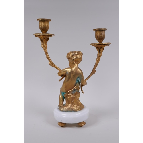 49 - A gilt metal two branch candlestick in the form of a putti, 30cm high