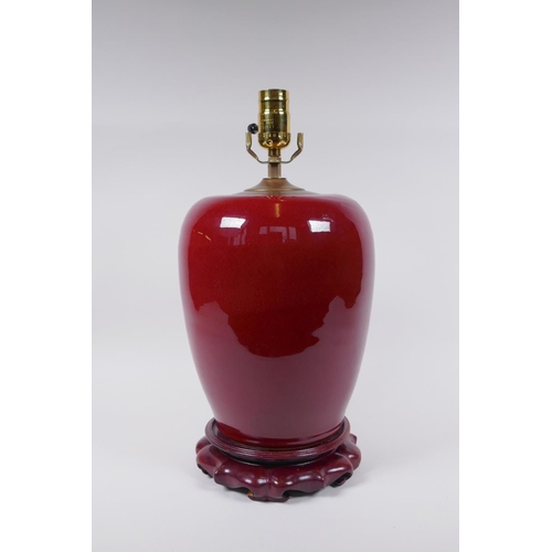 50 - A Chinese flambe glazed ginger jar converted to a lamp with a hardwood stand, 40cm high