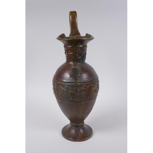 52 - A solid bronze ewer with cast Greco Roman style decoration, 35cm high