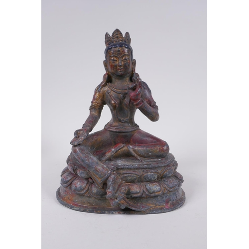 56 - A Sino Tibetan bronze figure of a female deity seated on a lotus throne, with the remnants of gilt a... 