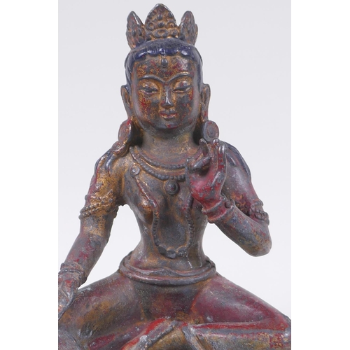 56 - A Sino Tibetan bronze figure of a female deity seated on a lotus throne, with the remnants of gilt a... 