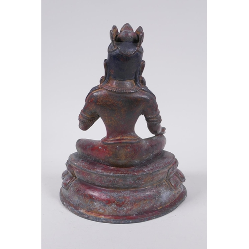 56 - A Sino Tibetan bronze figure of a female deity seated on a lotus throne, with the remnants of gilt a... 