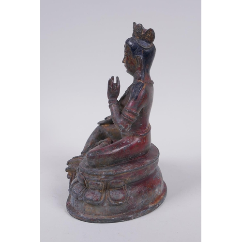 56 - A Sino Tibetan bronze figure of a female deity seated on a lotus throne, with the remnants of gilt a... 