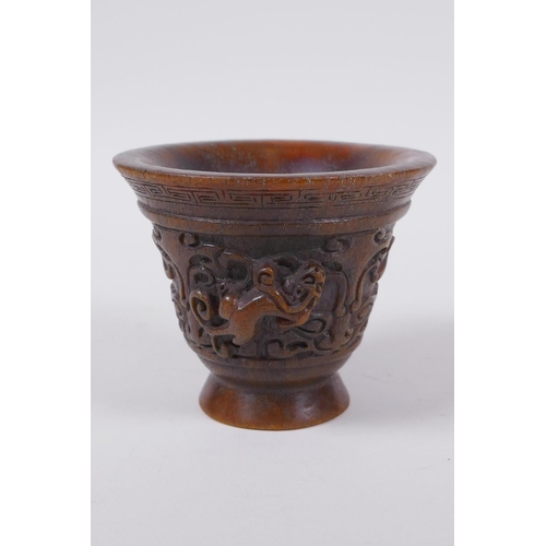 60 - A Chinese faux horn libation cup with raised kylin decoration, seal mark to base, 8cm high x 10cm di... 