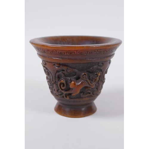 60 - A Chinese faux horn libation cup with raised kylin decoration, seal mark to base, 8cm high x 10cm di... 