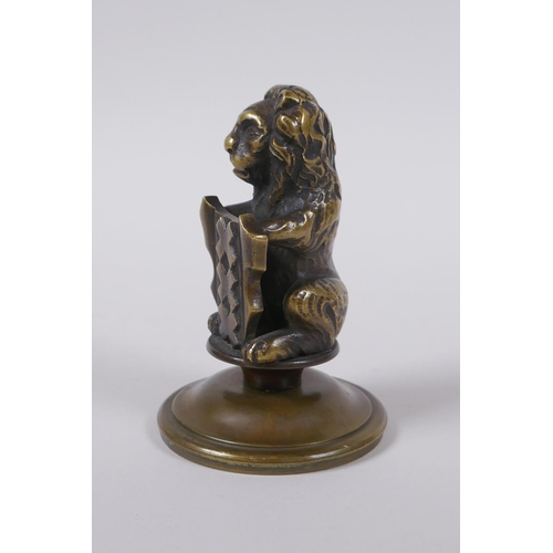 67 - A bronze heraldic mount in the form of a lion with a shield, 10cm high