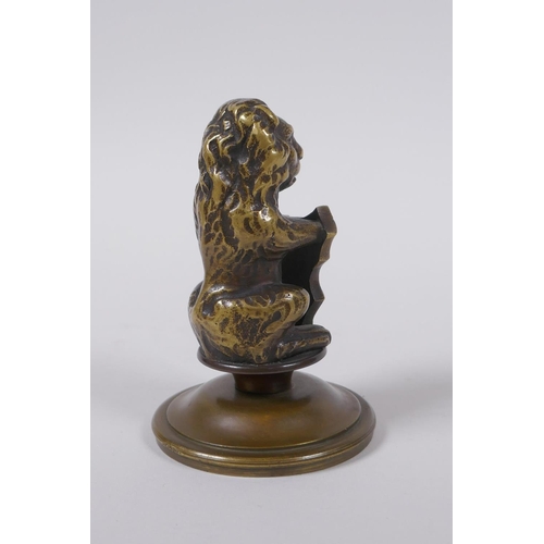 67 - A bronze heraldic mount in the form of a lion with a shield, 10cm high