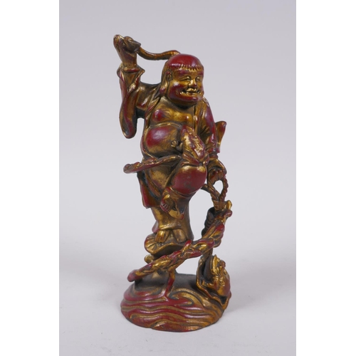 76 - A Chinese gilt and coppered bronze Lohan and toads, 16cm high