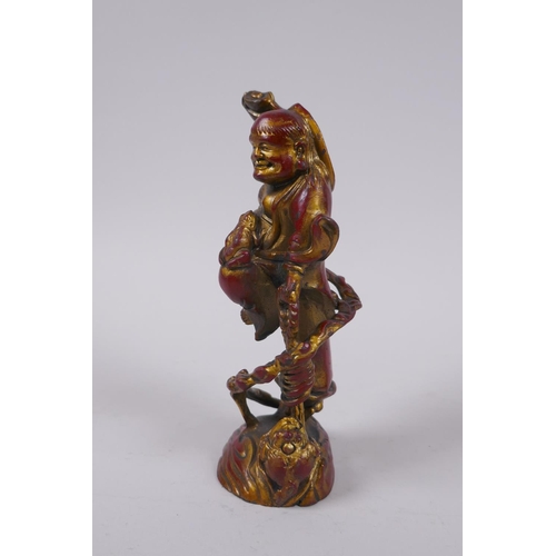 76 - A Chinese gilt and coppered bronze Lohan and toads, 16cm high