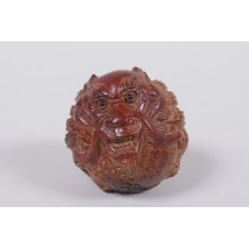 85 - A Japanese carved hardwood netsuke with dragon decoration, signed, 4cm diameter