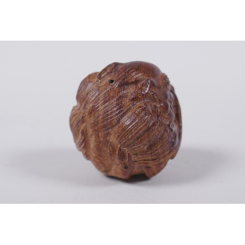 85 - A Japanese carved hardwood netsuke with dragon decoration, signed, 4cm diameter