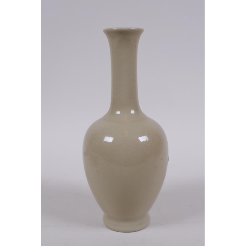 302 - A Chinese porcelain vase with a buff glaze and slender neck, 20cm high