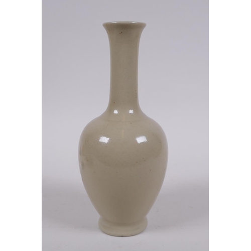 302 - A Chinese porcelain vase with a buff glaze and slender neck, 20cm high