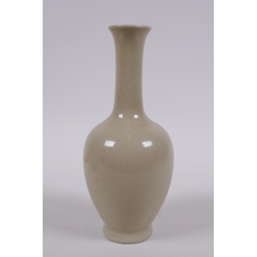 302 - A Chinese porcelain vase with a buff glaze and slender neck, 20cm high