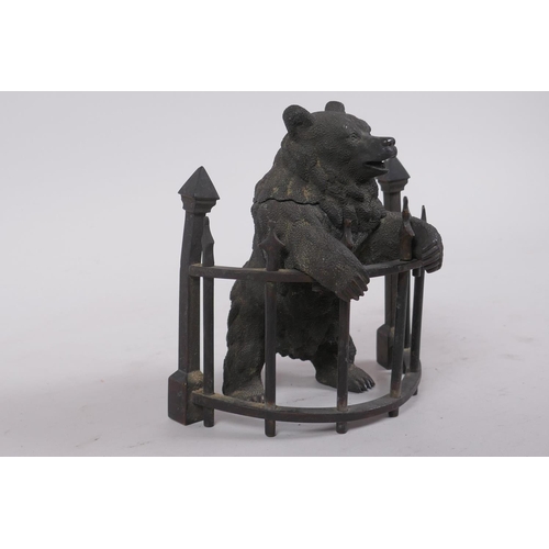 1 - A C19th finely cast patinated bronze inkwell in the form of a bear behind railings, 12cm high