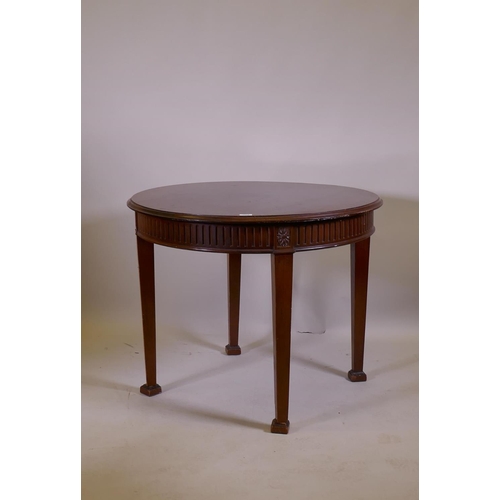 1018 - An Adam style mahogany centre table, with fluted frieze and patarae  decoration, raised on square ta... 