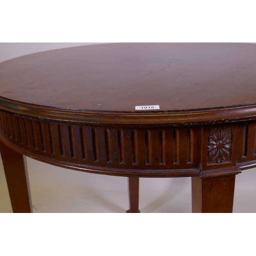 1018 - An Adam style mahogany centre table, with fluted frieze and patarae  decoration, raised on square ta... 