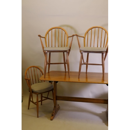 1022 - An Ercol 1960s elm Old Colonial refectory table, four Ercol elm and beech hoop back Windsor armchair... 