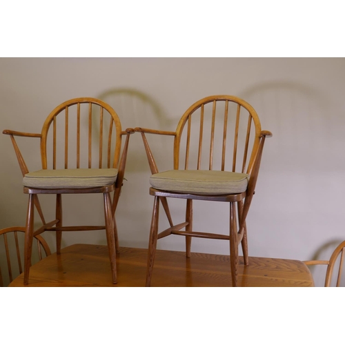 1022 - An Ercol 1960s elm Old Colonial refectory table, four Ercol elm and beech hoop back Windsor armchair... 