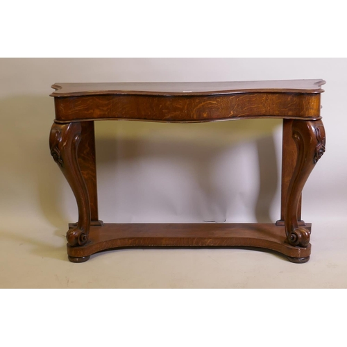 1023 - A Victorian oak serpentine console table on carved scrolled cabriole supports united by an under tie... 