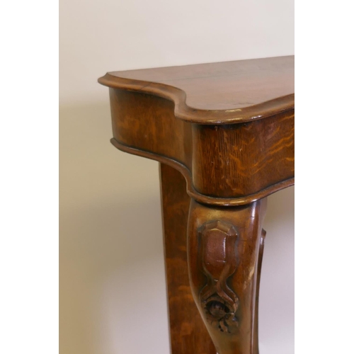 1023 - A Victorian oak serpentine console table on carved scrolled cabriole supports united by an under tie... 