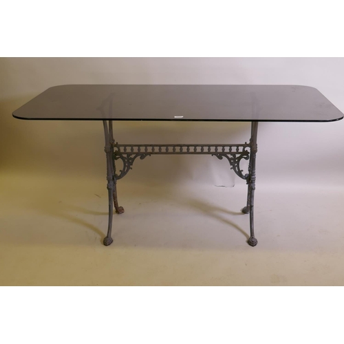 1026 - An antique painted cast iron table base with an associated glass top, 152 x 81cm, 72cm high