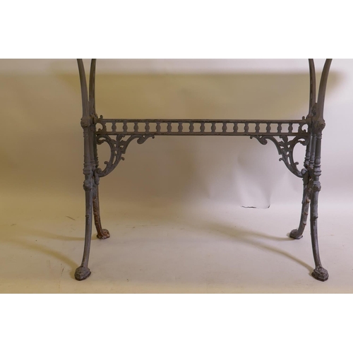 1026 - An antique painted cast iron table base with an associated glass top, 152 x 81cm, 72cm high