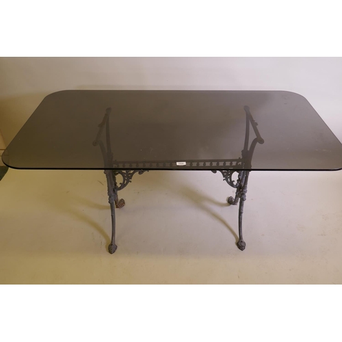 1026 - An antique painted cast iron table base with an associated glass top, 152 x 81cm, 72cm high