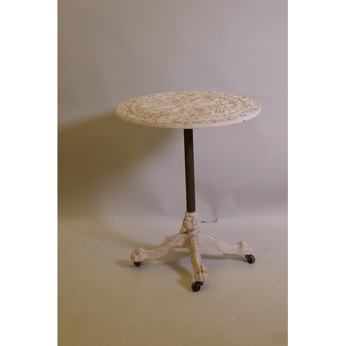 1027 - A painted wrought iron garden table with paw feet and brass castors, 60cm diameter, 68cm high