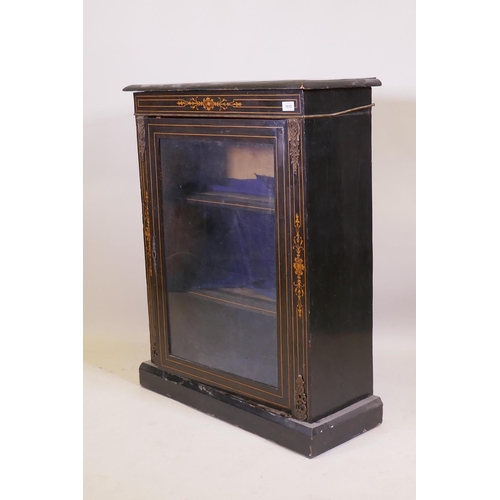 1035 - A Victorian ebonised and inlaid pier cabinet with brass mounts and single glazed door, raised on a p... 