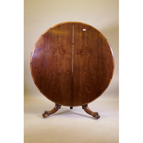 1037 - A Victorian rosewood tilt top breakfast table, raised on turned column tripod supports and carved cl... 