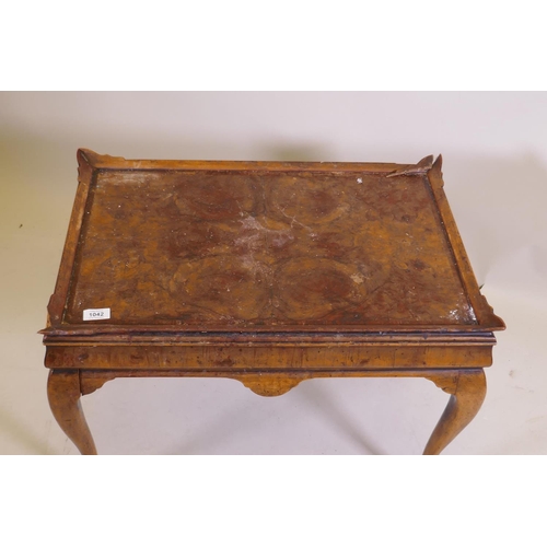 1042 - A figured walnut occasional table, with shaped gallery and cushion shaped frieze, raised on cabriole... 