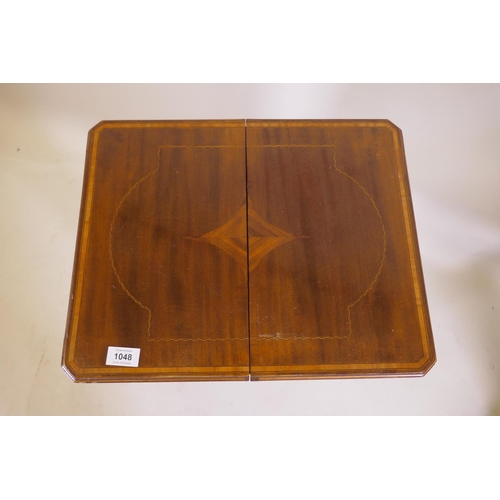 1048 - An Edwardian inlaid mahogany work table, the fold over top opening to reveal a fitted interior with ... 