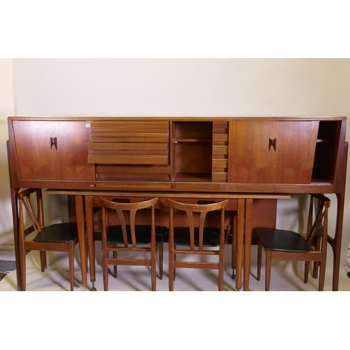 1058 - A mid century Elliott of Newbury teak credenza with sliding doors and three drawers, a pull out fold... 