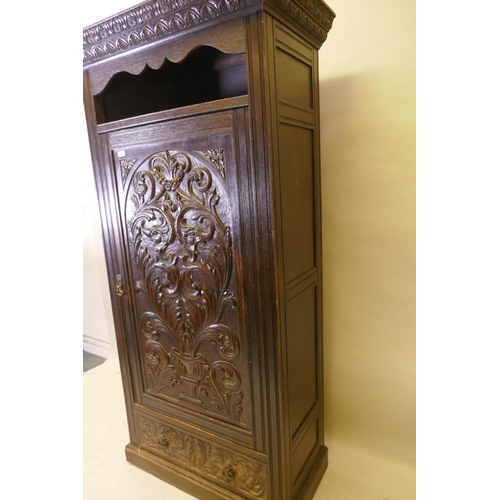 1059 - A C19th oak hall cupboard with single door over a drawer and carved decoration in the Renaissance Re... 