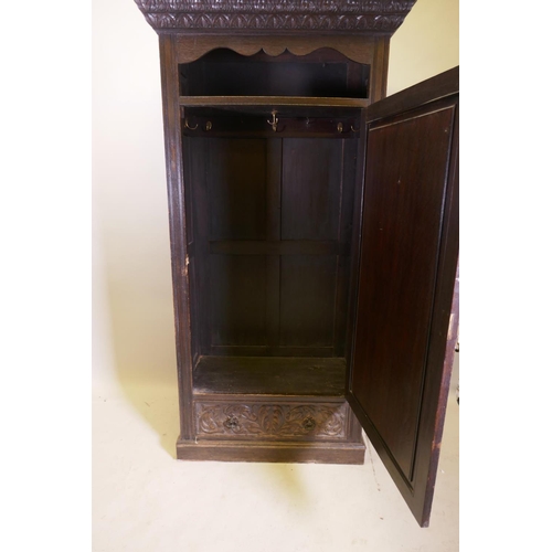 1059 - A C19th oak hall cupboard with single door over a drawer and carved decoration in the Renaissance Re... 