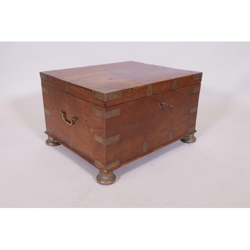 1070 - A C19th teak Anglo Indian vanity chest with campaign style brass mounts and handles, raided on brass... 