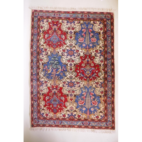 1080 - An Iranian cream ground wool rug with blue and red panelled design, 112 x 156cm