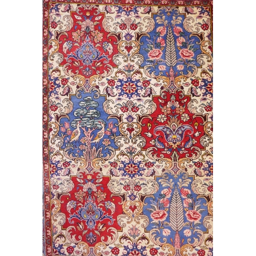 1080 - An Iranian cream ground wool rug with blue and red panelled design, 112 x 156cm