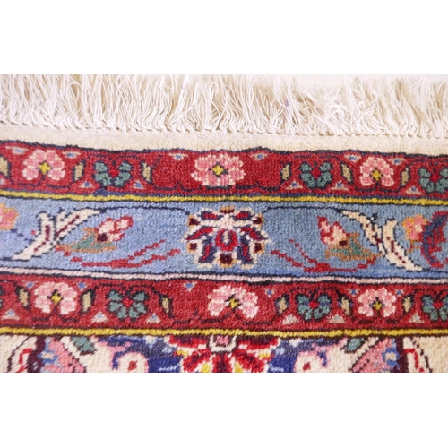 1080 - An Iranian cream ground wool rug with blue and red panelled design, 112 x 156cm