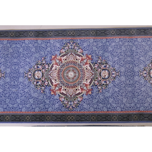 1081 - An Iranian fine woven blue ground runner with a medallion design surrounded by an embossed all over ... 