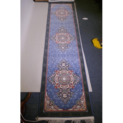 1081 - An Iranian fine woven blue ground runner with a medallion design surrounded by an embossed all over ... 