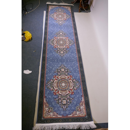 1081 - An Iranian fine woven blue ground runner with a medallion design surrounded by an embossed all over ... 